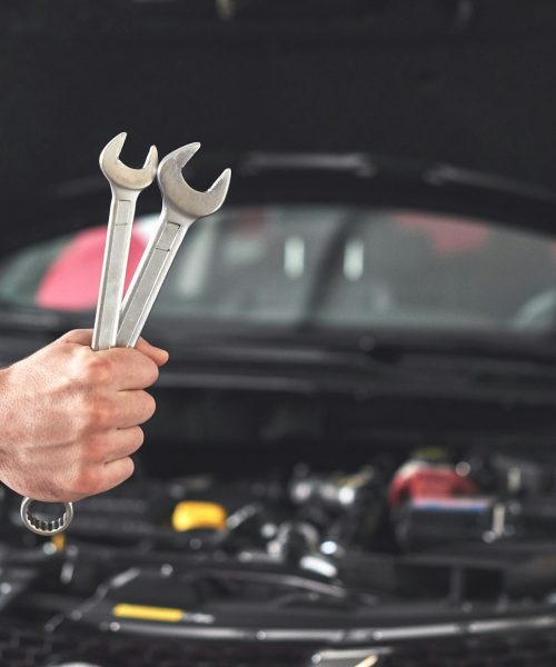 mechanic-holding-pair-of-wrenches-at-the-repair-garage